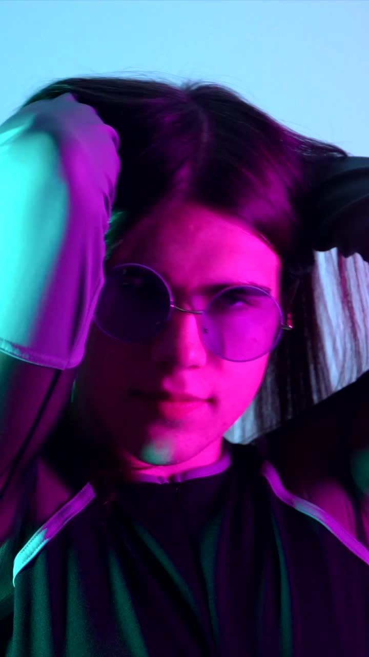 Person with long hair and sunglasses in a studio setting