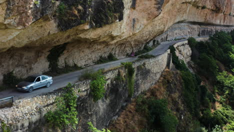 pan up reveal of the dramatic mirador al puente romano and a woman walking her dog