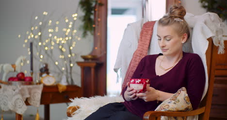 Woman-Relaxing-While-Sitting-With-Coffee-Cup-At-Home