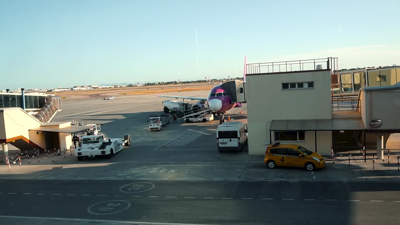 Airport Workers Loading Baggages And Cargo Into An Aircraft By Baggage Belt Conveyor Loader In Valencia Airport, Spain. - timelapse