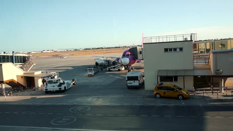 airport workers loading baggages and cargo into an aircraft by baggage belt conveyor loader in valencia airport, spain. - timelapse