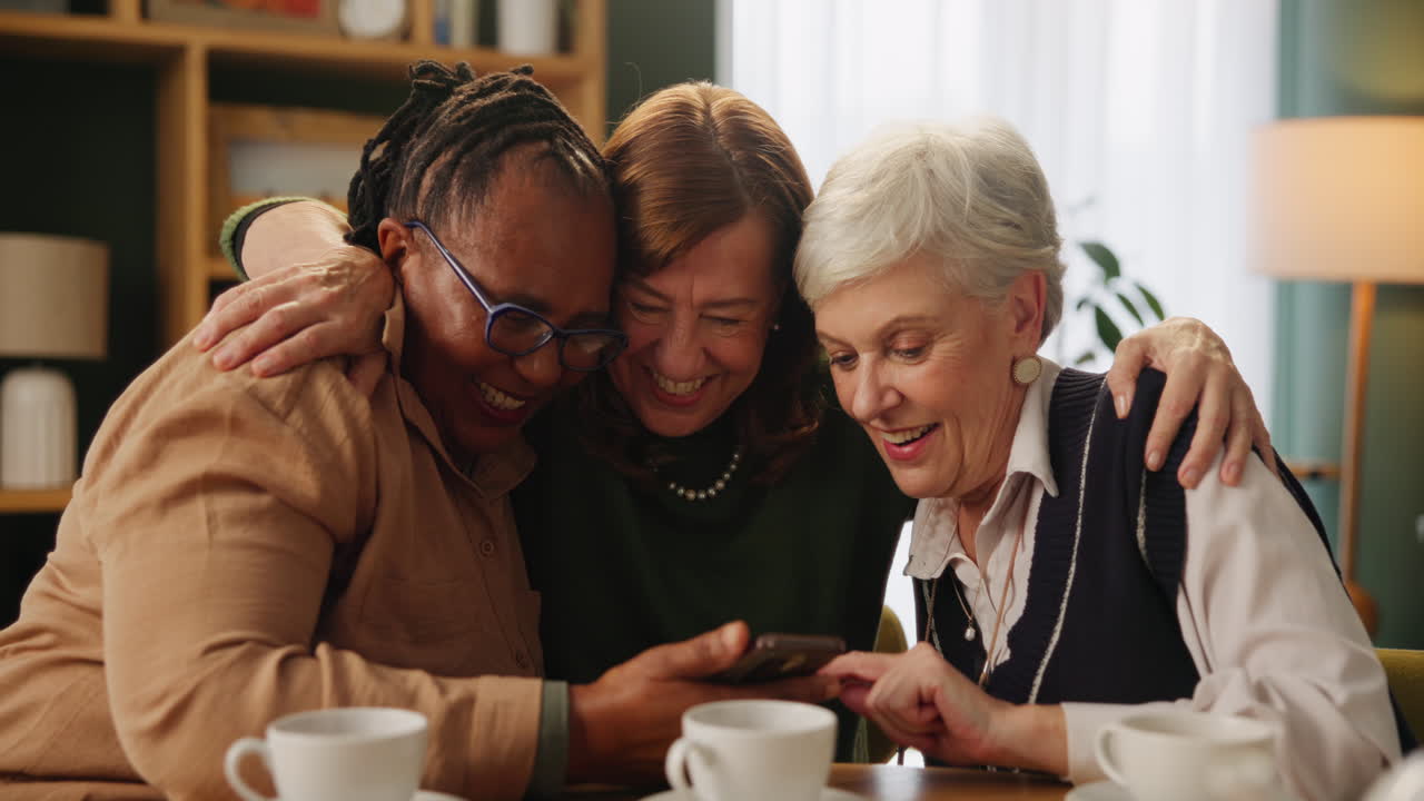 Three women laughing at a smartphone