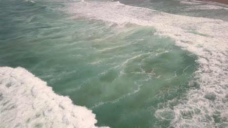 Aerial-dolly-out-shot-of-waves-in-Portugal