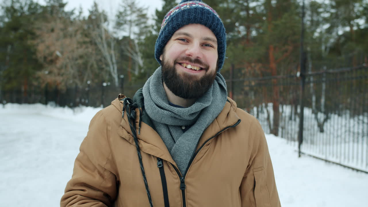Smilende mann i vinterpark