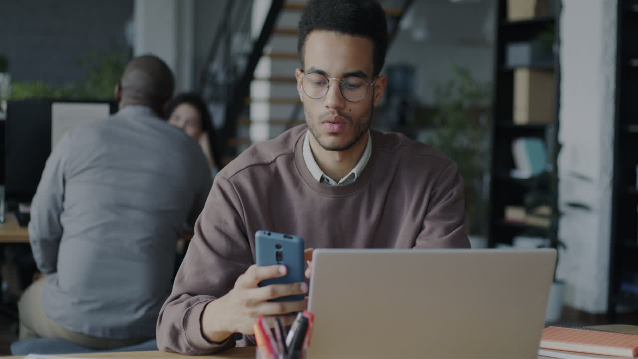 Man Working on Laptop and Mobile Phone in Office