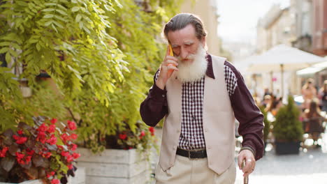 Hombre-Feliz-Abuelo-Teniendo-Conversación-Remota-Hablar-En-Smartphone-Chismes-De-Buenas-Noticias-En-Las-Calles-De-La-Ciudad