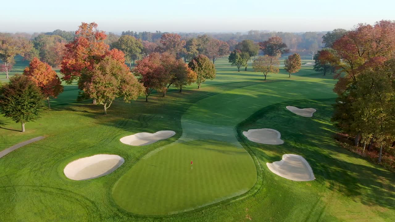 골프 코스 페어웨이, 깃발, 모래 덫 해저드, 단풍, 일출이 아침 안개를 비추는 공중 회전