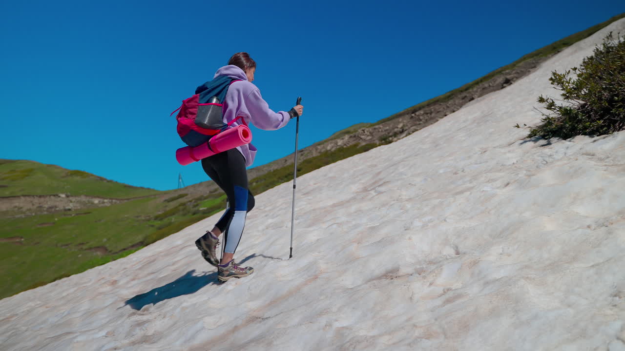 mujer caminando en montañas nevadas