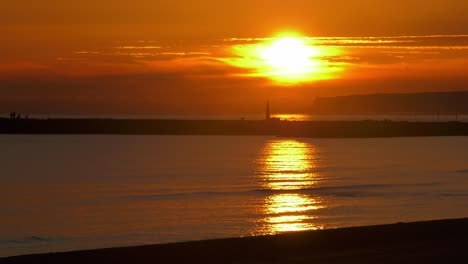 Dunstiger-Goldener-Sonnenaufgang-über-Ruhigen-Meereswellen,-Küstenmeerlandschaft