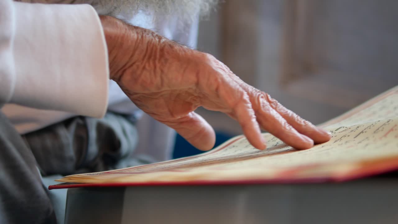 Mano di un uomo che legge dal Corano