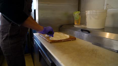 baker frosting a cake in a commercial kitchen