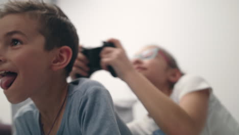 joyful kids face playing video game with joystick. children playing video games