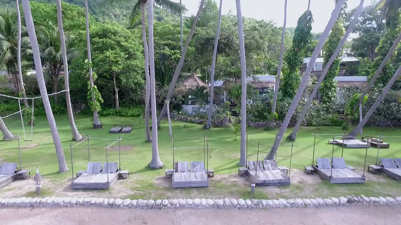 해변 태국에서 두 야자수 사이 드론 비행 돌리 다시