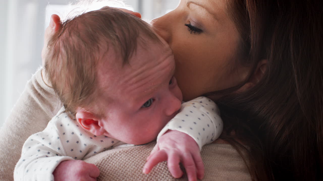 사랑 하는 어머니 가 집 에서 새로 태어난 아기 소년 을  ⁇ 안고 자고 있다