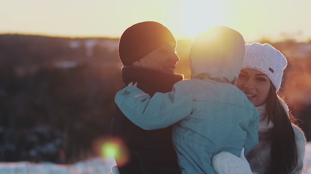 남자는 어린 아들을 품에 안고 있고 예쁜 여자는 가족을 껴안고 있습니다.