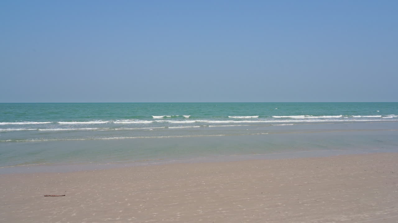 Calm ocean waves rolling onto tropical beach