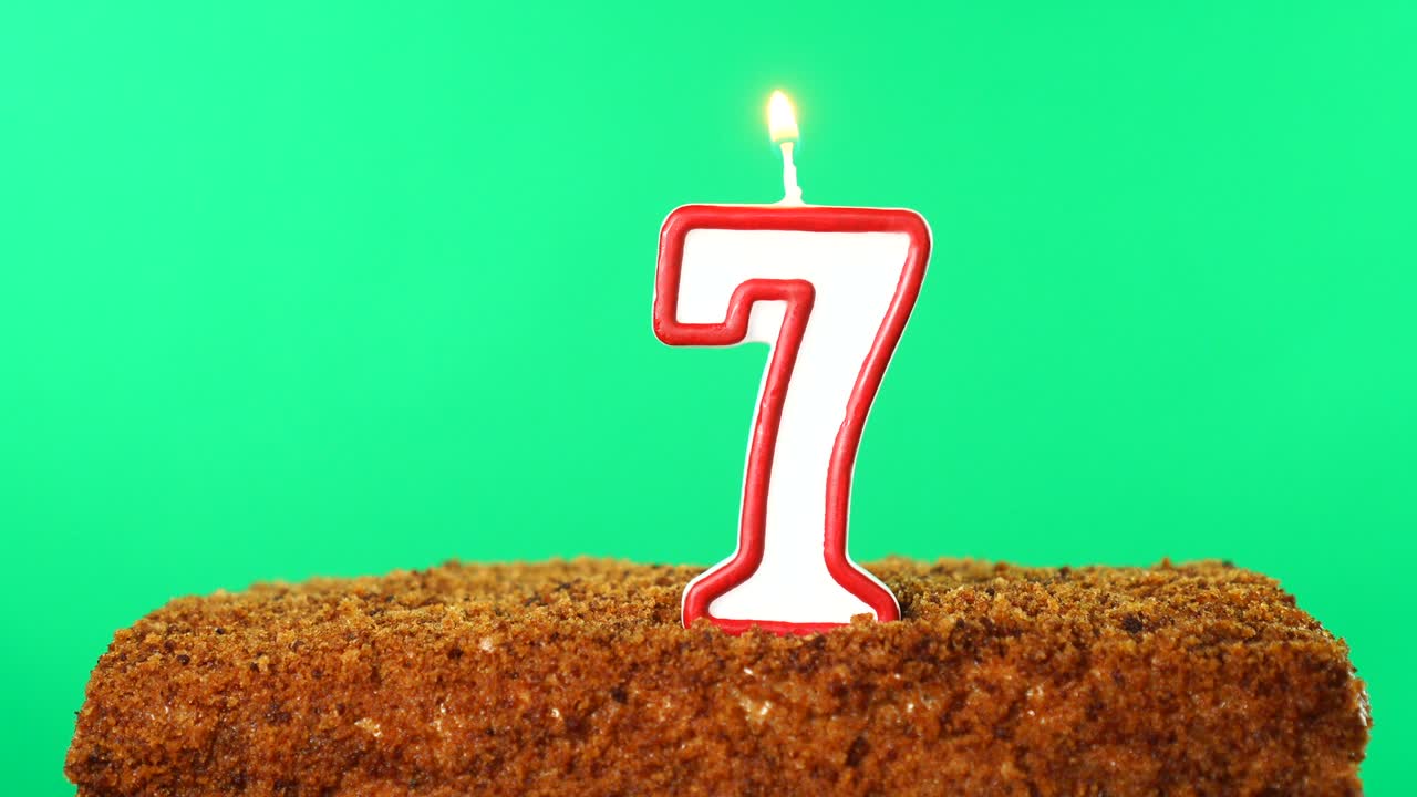 Cake with the number 7 lighted candle. Chroma key. Green Screen. Isolated