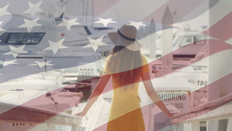 american flag waving against rear view of woman standing on a harbor