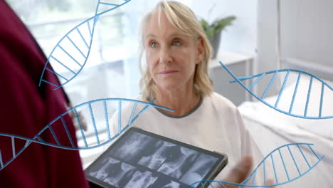 animation of dna strands over diverse male doctor with tablet and senior female patient