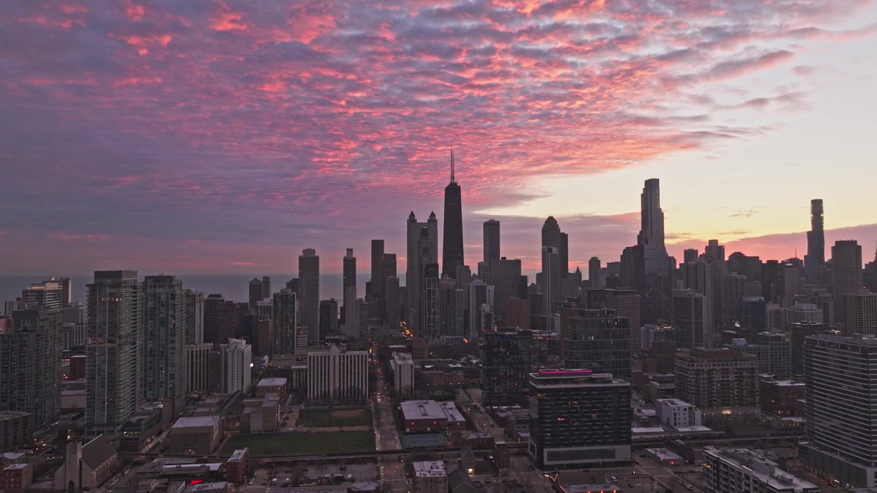 Vista aérea de drone do horizonte de Chicago silhuetada contra um dramático céu de nascer do sol rosa e laranja