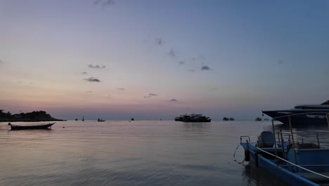 Ruhige-Gewässer-Vor-Koh-Tao,-Thailand,-Die-Heitere-Abendstimmung,-Während-Fischerboote-Sanft-Auf-Der-Oberfläche-Schwimmen,-Während-In-Der-Ferne-Ausflugsboote-In-Der-Bucht-Ankommen-Und-Eine-Friedliche-Szene-Zeichnen