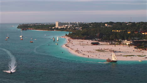 Sandy-beach-in-Zanzibar-at-sunset,-where-tourists-and-locals-spend-wonderful-evenings-in-harmony,-Kendwa,Tanzania