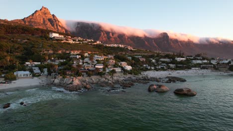 Clifton-beaches-during-sunset-with-clouds-rolling-over-12-Apostles,-aerial