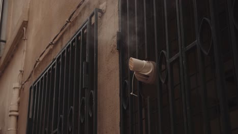 smoke tube ventilation outside a building's grilled window