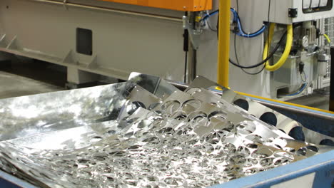 worker stacking sheet metal in a bin, power press production