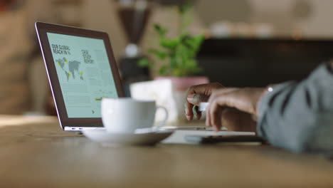 Hombre-De-Negocios-Afroamericano-Usando-Una-Computadora-Portátil-En-Una-Cafetería-Tomando-Café-Escribiendo-Documentos-Trabajando-En-Línea-Enviando-Correo-Electrónico-Empresario-Independiente-Disfrutando-De-Una-Mañana-Relajada-Haciendo-Contactos-De-Cerca