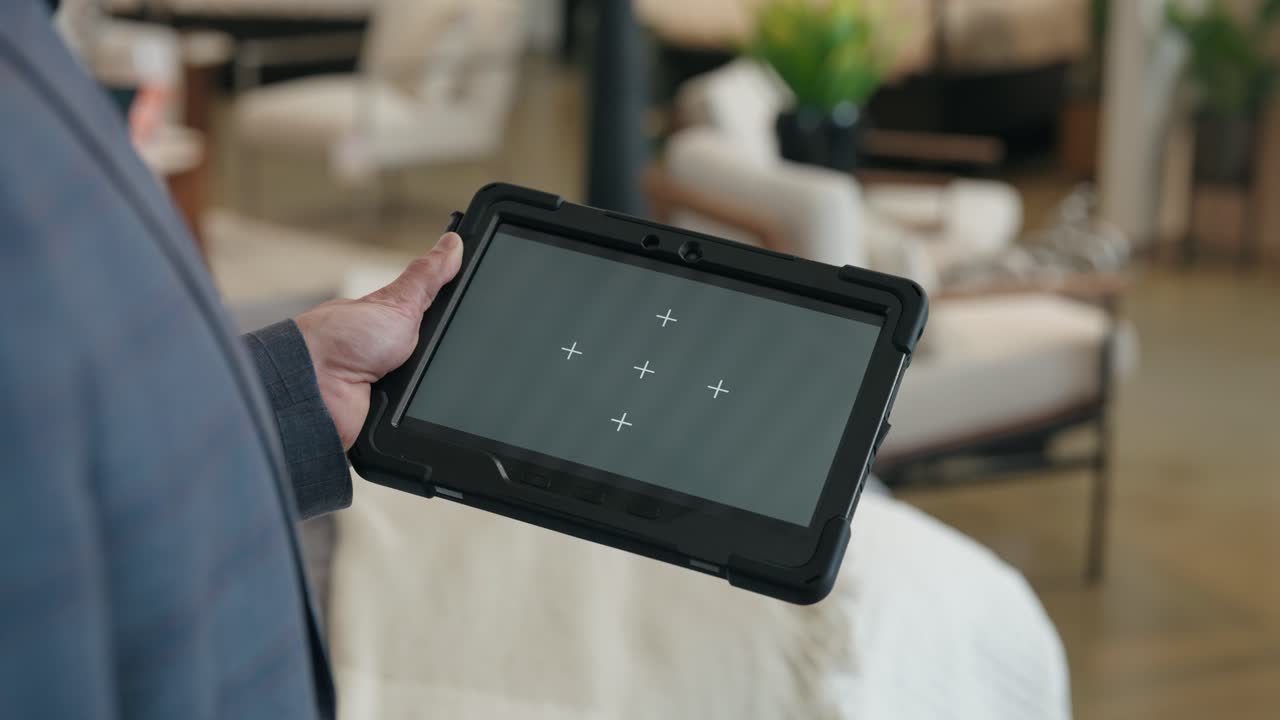 Hands display grey screen tablet as camera arcs in slow motion around device