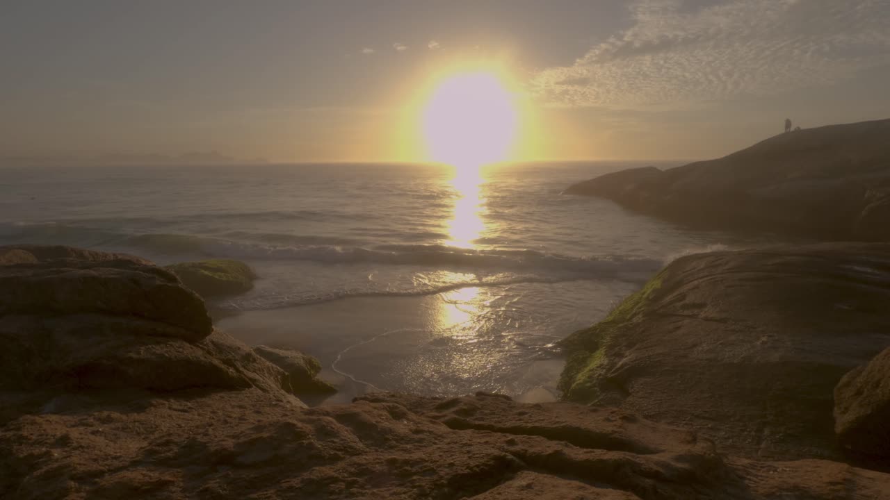 Tidsforløb af solopgang ved den lille klippestrand mellem klipperne ved Arpoador i Rio de Janeiro, Brasilien