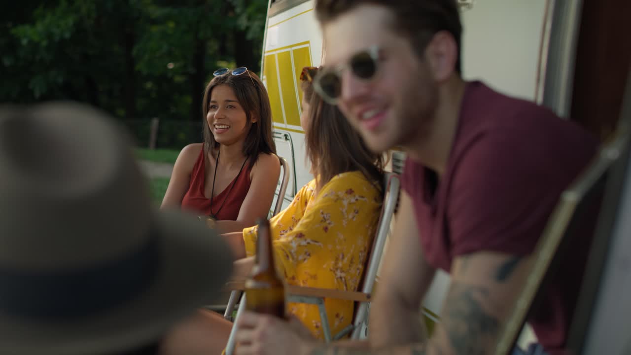 video de amigos jóvenes sentados y hablando en el campamento