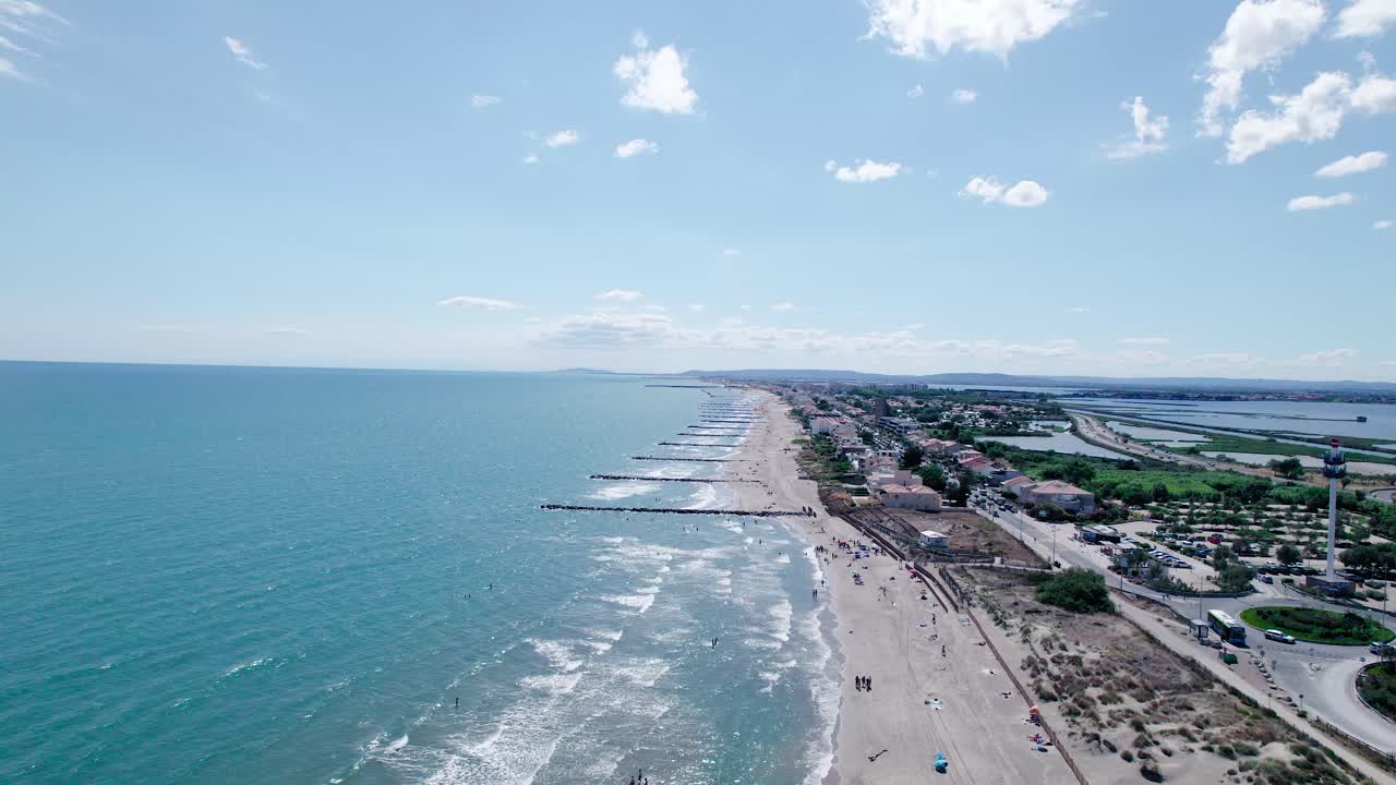 toma aérea de camiones de playa de arena con embarcadero y azul riviera francesa en la grande motte - tiro ancho