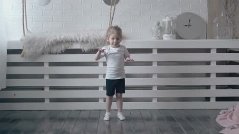 fair haired daughter in white t-shirt does squat exercises