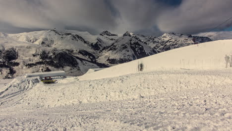 lapso de tiempo de las nubes blancas que vuelan sobre los picos nevados de las montañas - los peluqueros preparan el parque de nieve para el evento de los nueve caballeros de suzuki, livigno, italia
