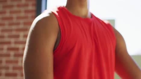 Fit-african-american-man-exercising-at-home-and-doing-stretching-at-home