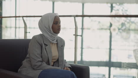mujer negra bonita con ropa casual con hijab en la oficina