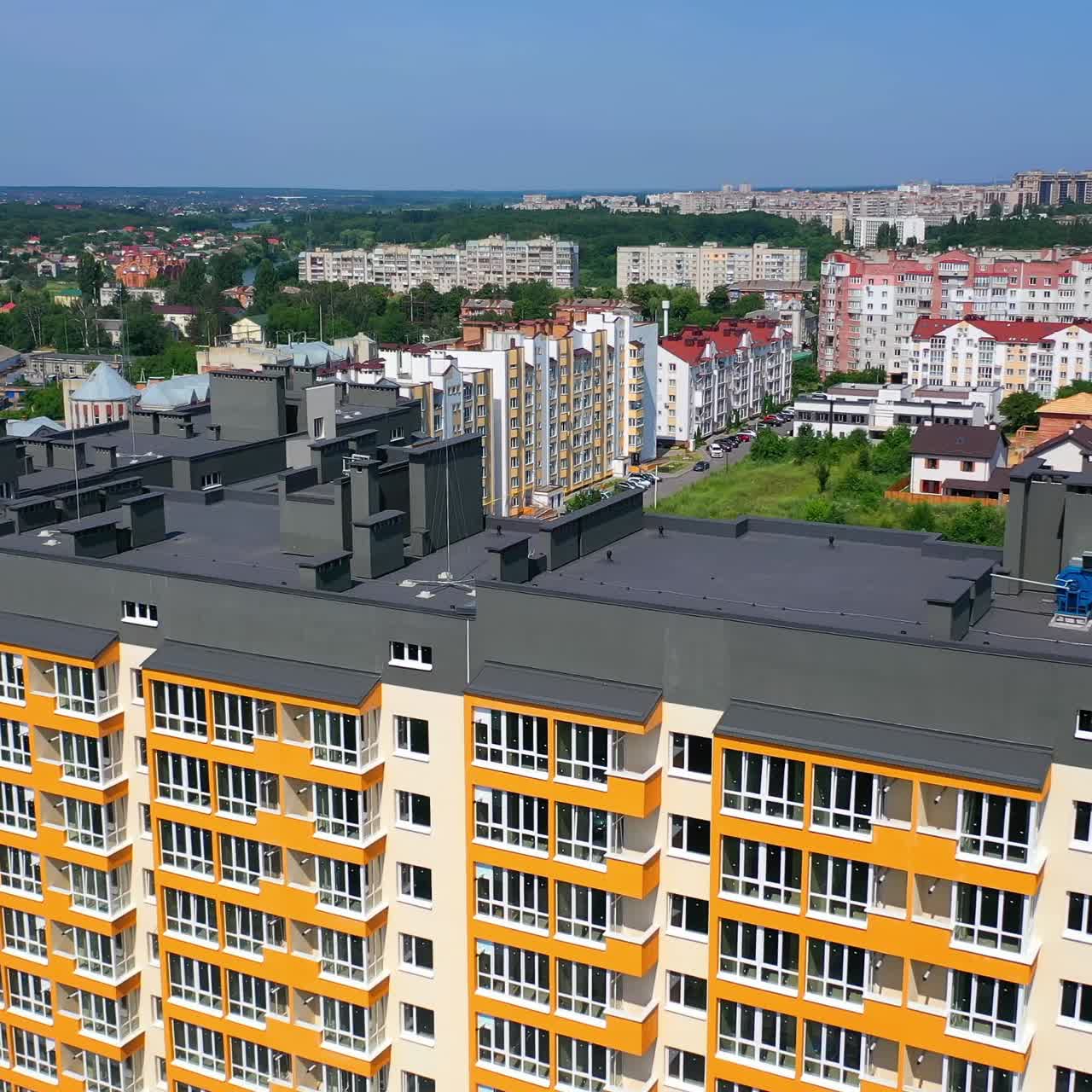 Contemporary block of flats among city landscape. Modern multi-storey building of new design. New landmark in the city. View from above