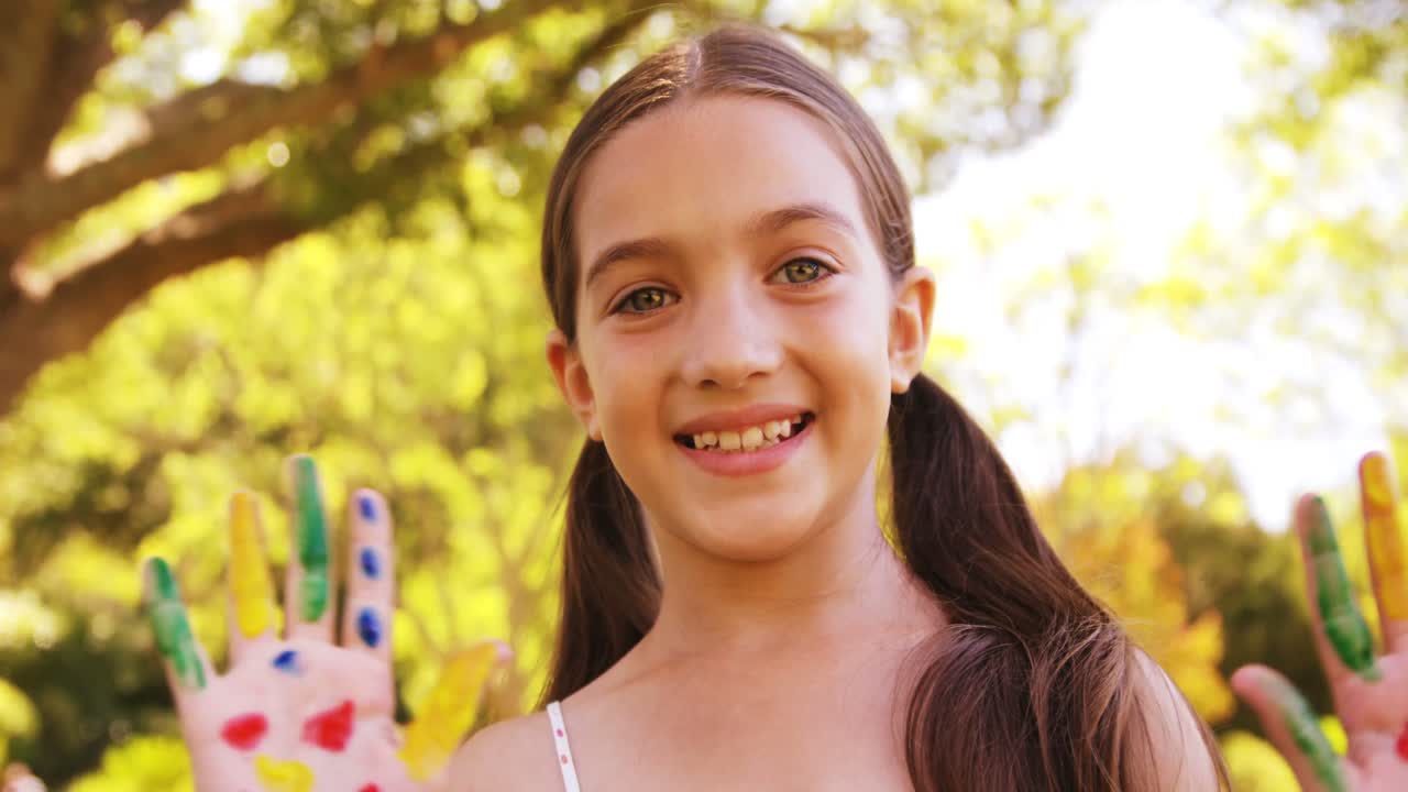 chica feliz con las manos pintadas en colores de agua