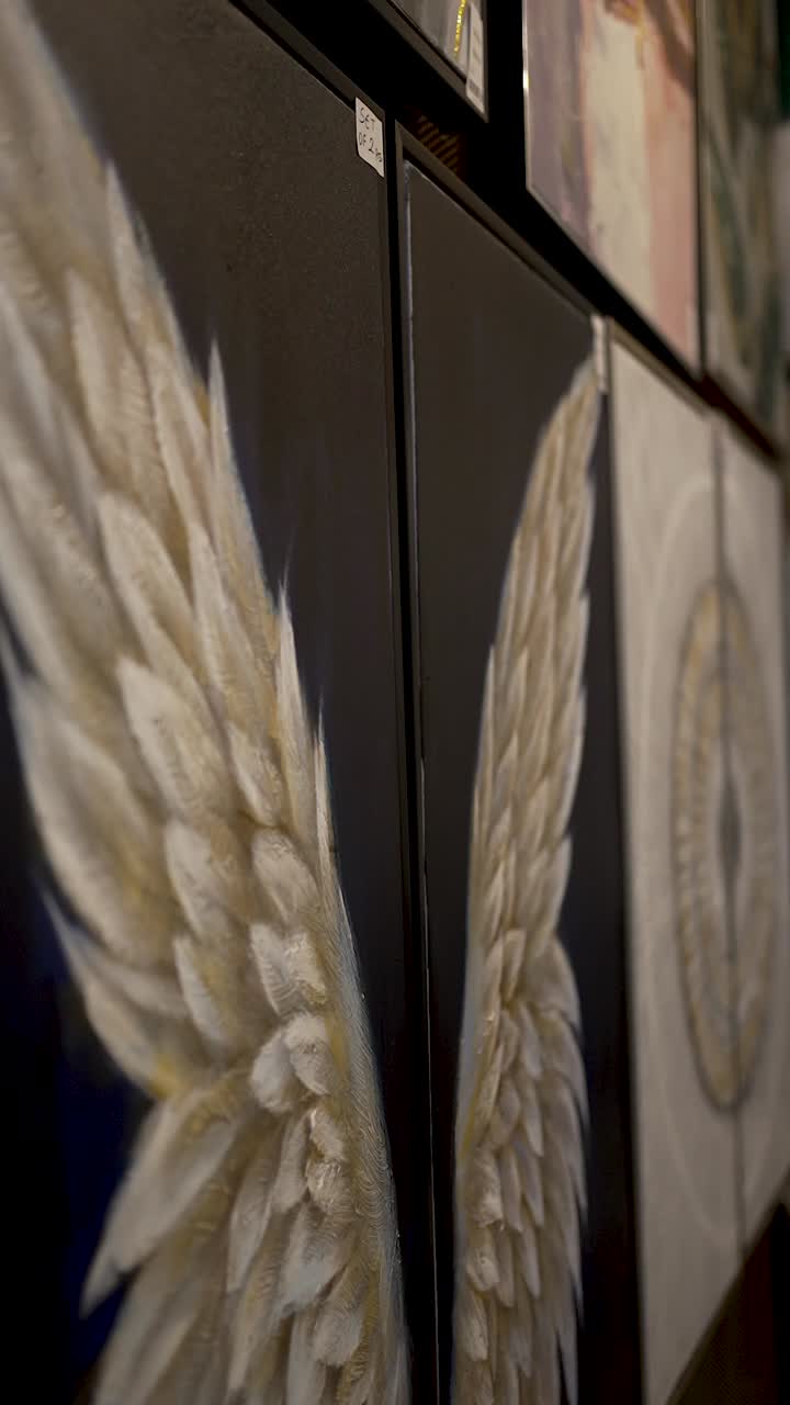 Stunning angel wings artwork is showcased on the wall, creating a serene atmosphere. This space invites visitors to appreciate the intricate details of each piece