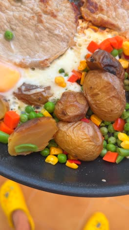 sizzling steak and eggs with roasted potatoes and mixed vegetables