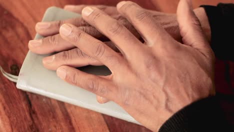 rezando con la mano en la biblia con mesa marrón almacen de video