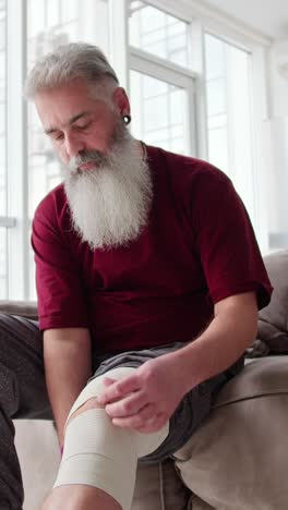 man applying knee brace at home