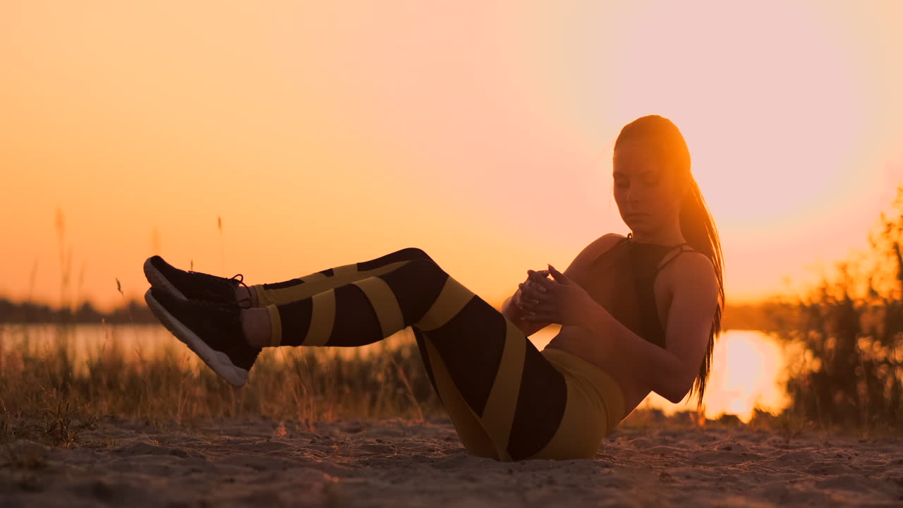 Fitness woman doing crunches at the beach. Fitness woman doing crunches exercise workout towards the beach. Female fit athlete training abdominal midsection