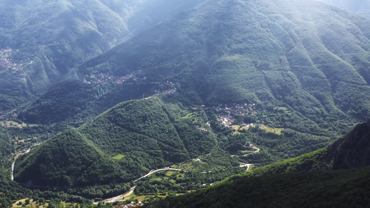 la luz del sol brilla sobre las altas montañas verdes del valle en el parque nacional de mavrovo