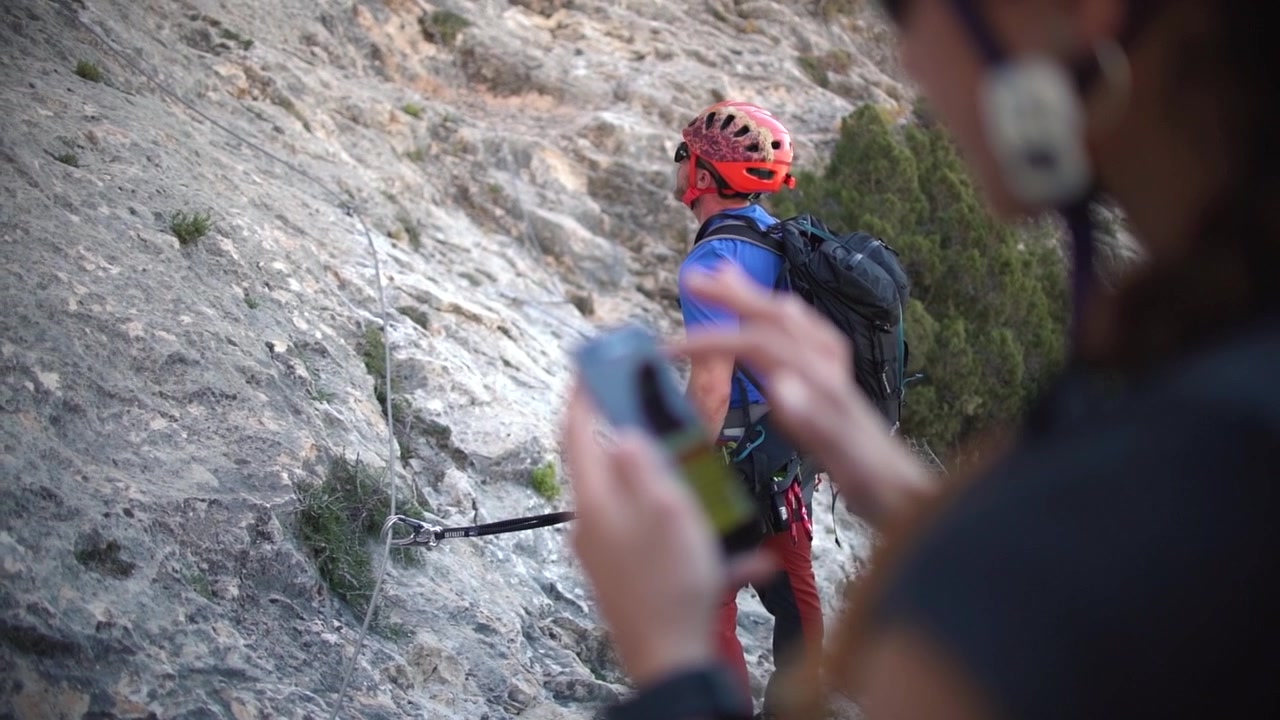 Via ferrata ascension by a couple sportsmen. View of mountain and mountaineers climbing in Alicante, Spain.
