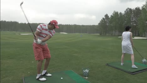 couple playing golf in the rain