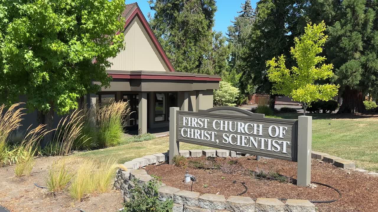 Calm church exterior in Ashland, Oregon, surrounded by lush greenery