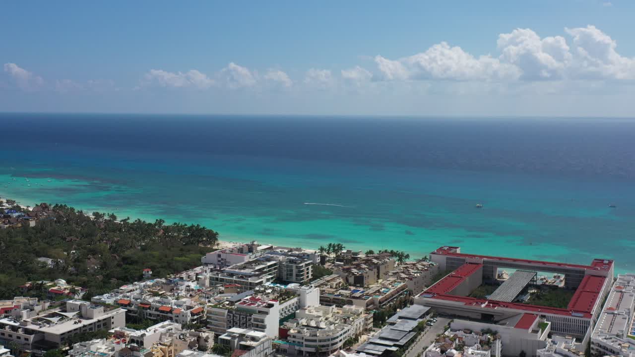 바다로 향하는 항공 샷은 카리브해의 건물과 큰 호텔을 보여줍니다